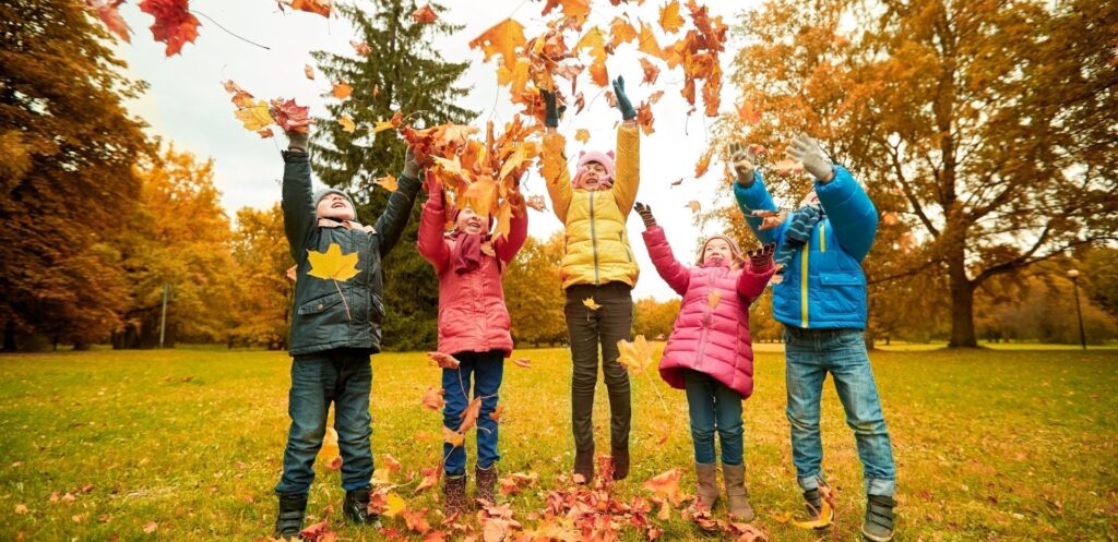 children throwing leaves in the air