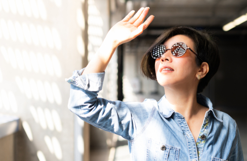 Woman in glasses trying to Keep the Sun out of her eyes.